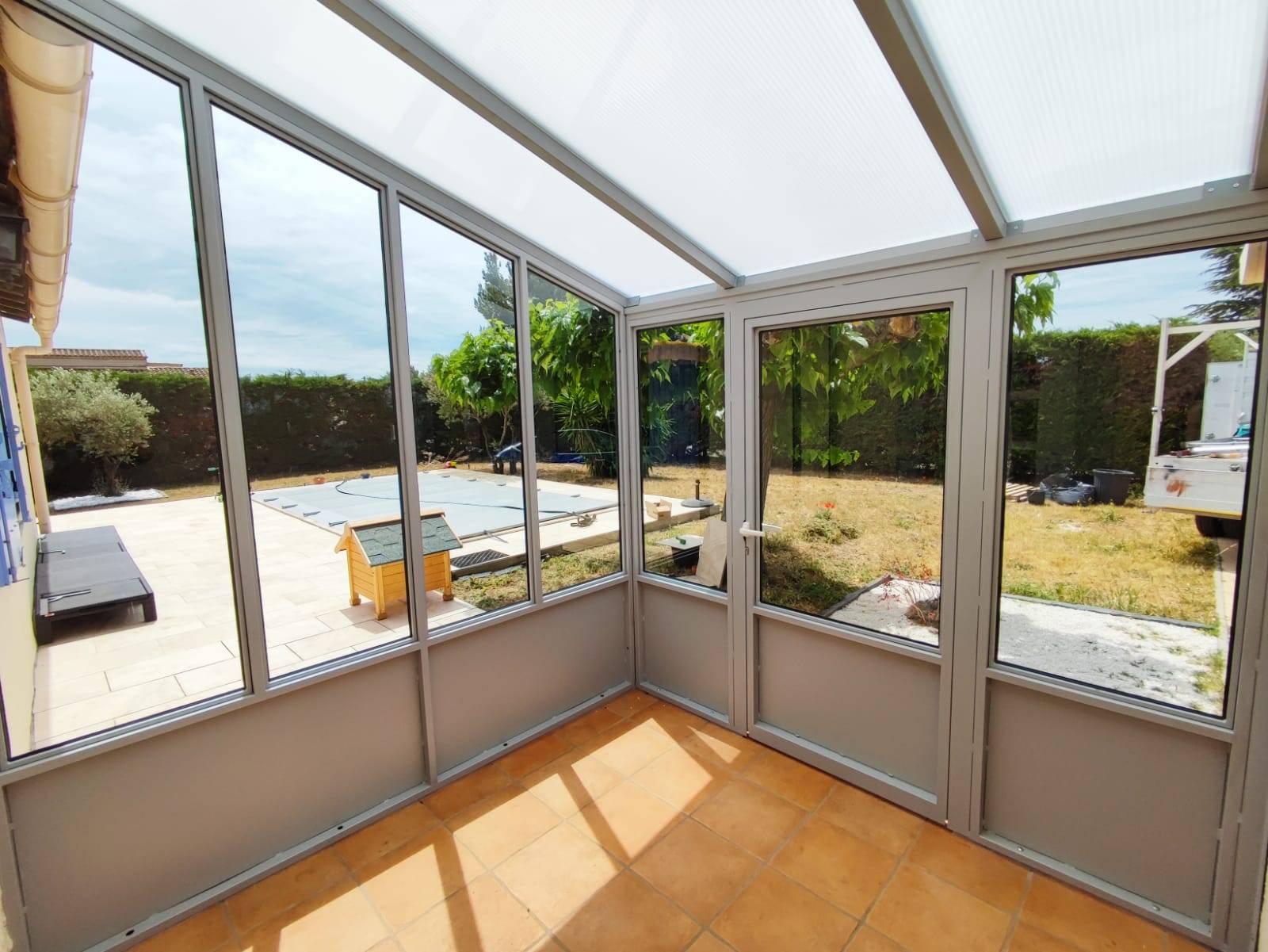 Création d'une véranda sur mesure en fer forgé thermolaquée grise et verre à Arles